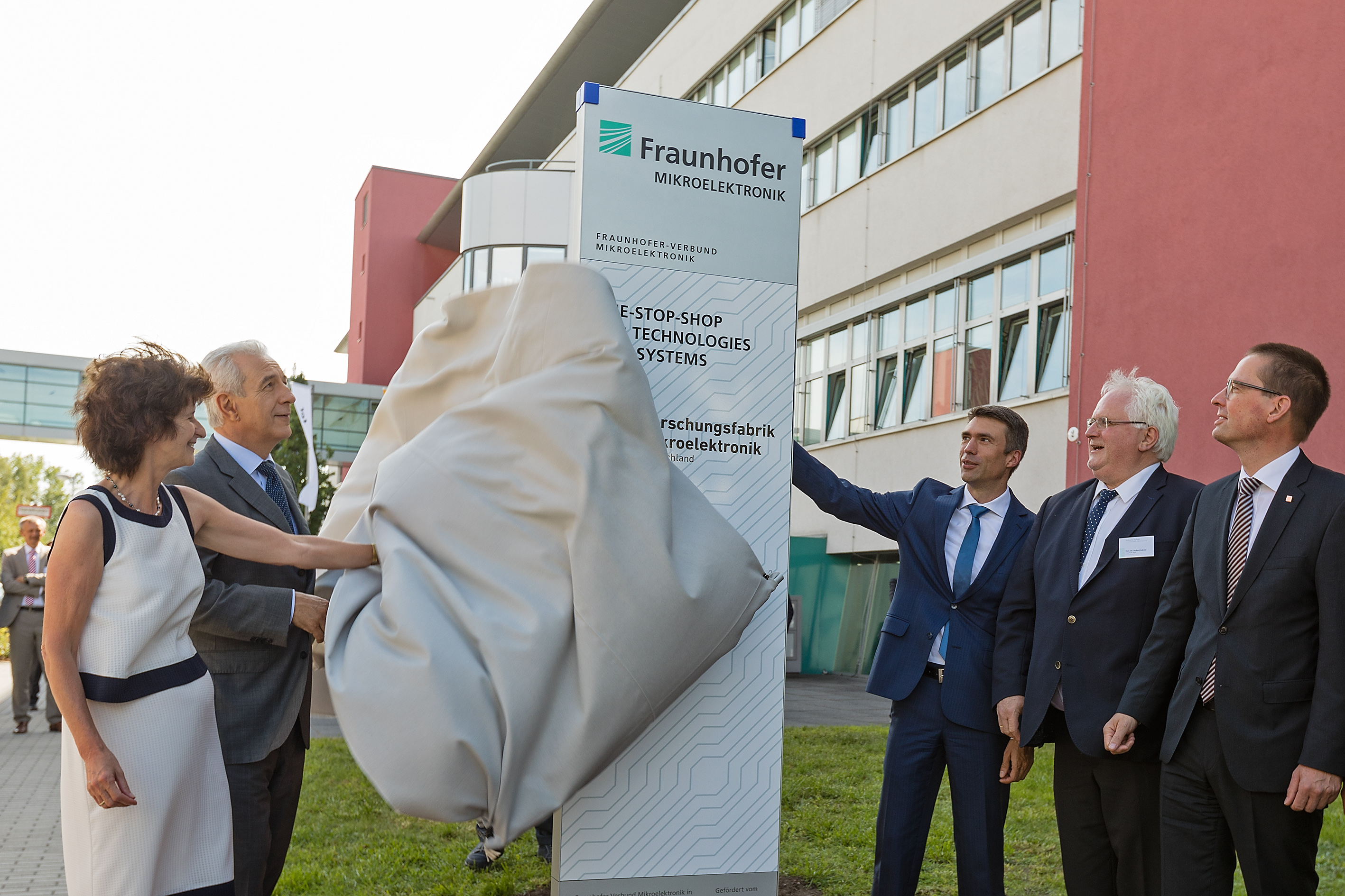 Dr. Eva-Maria Stange, Minister of Science for Saxony; Stanislaw Tillich, Minister president of the Free State of Saxony; and Stefan Müller, Parliamentary State Secretary at the Federal Ministry for Education and Research; along with Prof. Hubert Lakner, chair of the Steering Committee of the Research Fab Microelectronics; and Prof. Georg Rosenfeld, member of the executive board of the Fraunhofer Society (from left to right) at the symbolic unveiling of the entrance column at the Fraunhofer Institute for photonic measurement systems in Dresden.